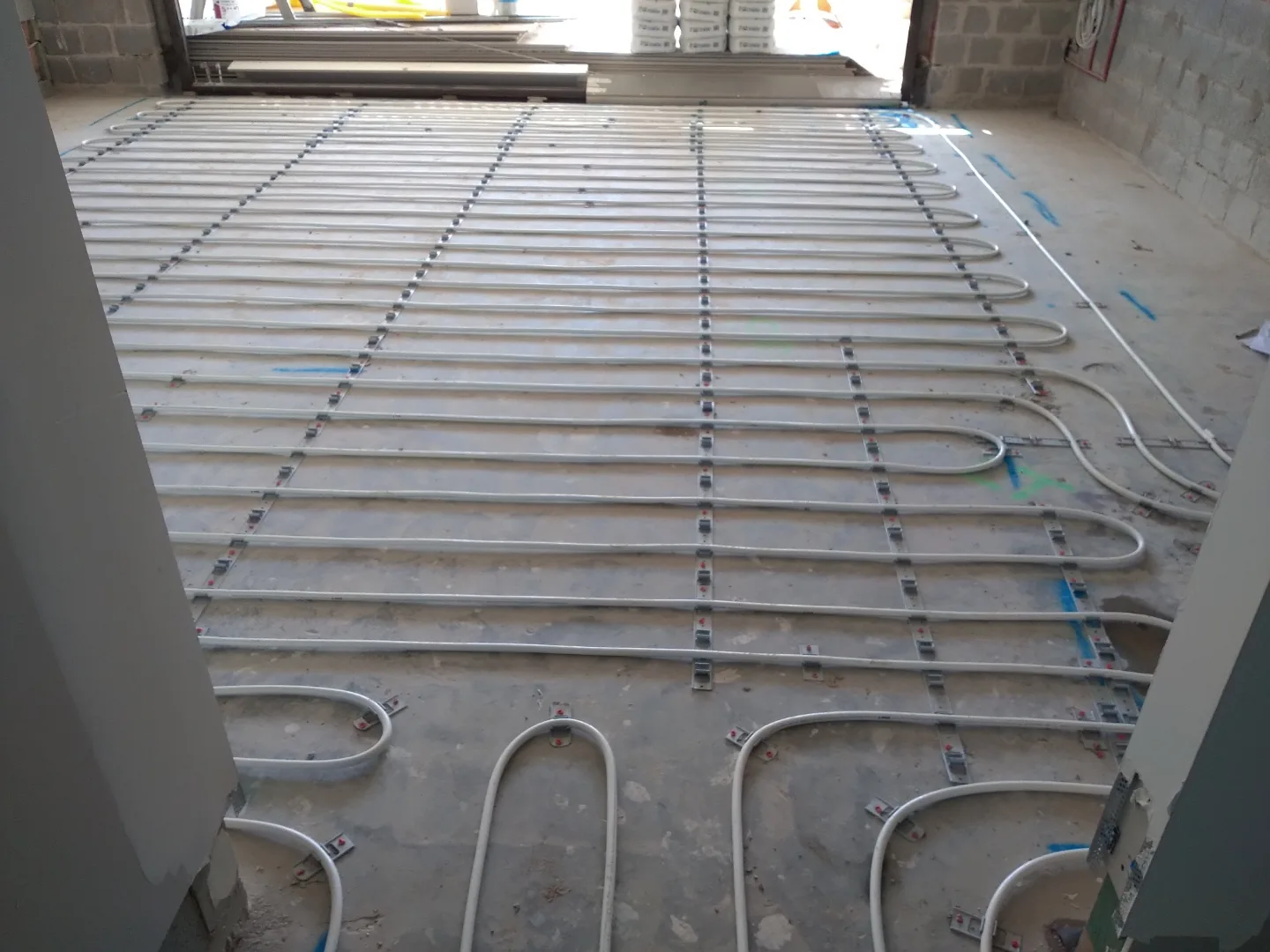 In-screed hydronic heating pipework fixed above a structural slab