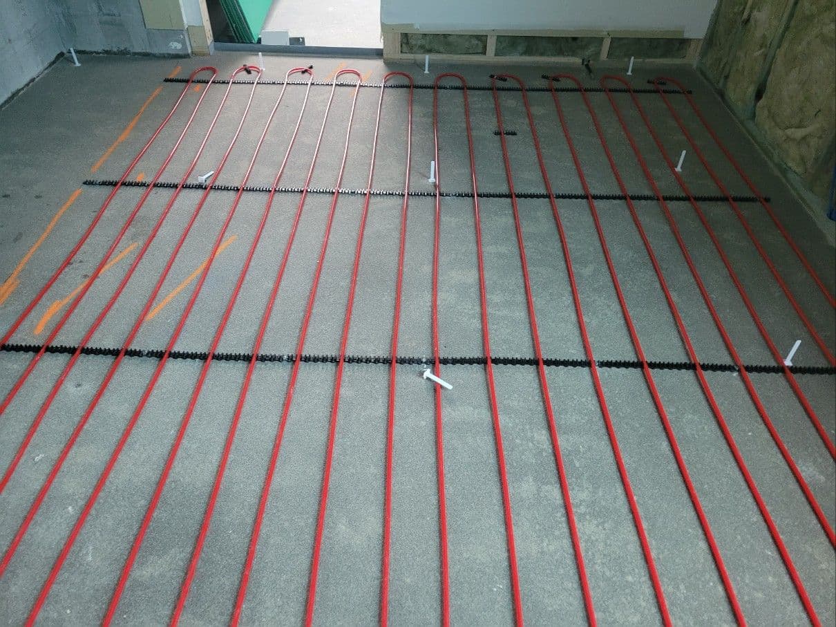 Multi-zone hydronic pipe layout installed through hallways and adjoining rooms.