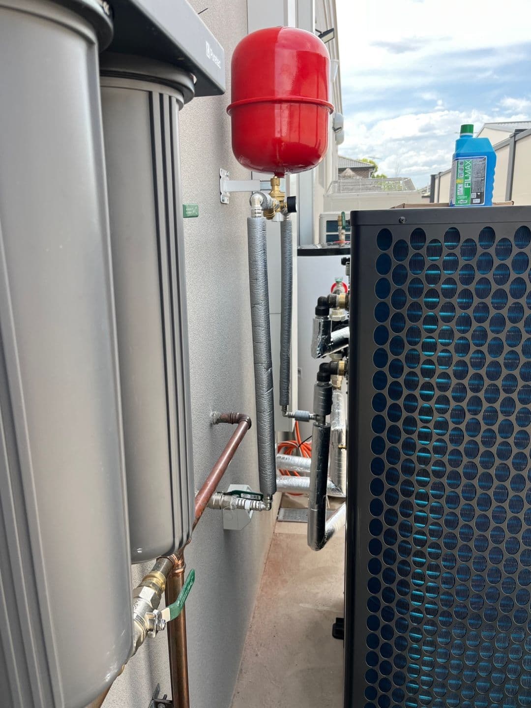 Residential inverter heat pump with coordinated external hydronic pipework and buffer storage.
