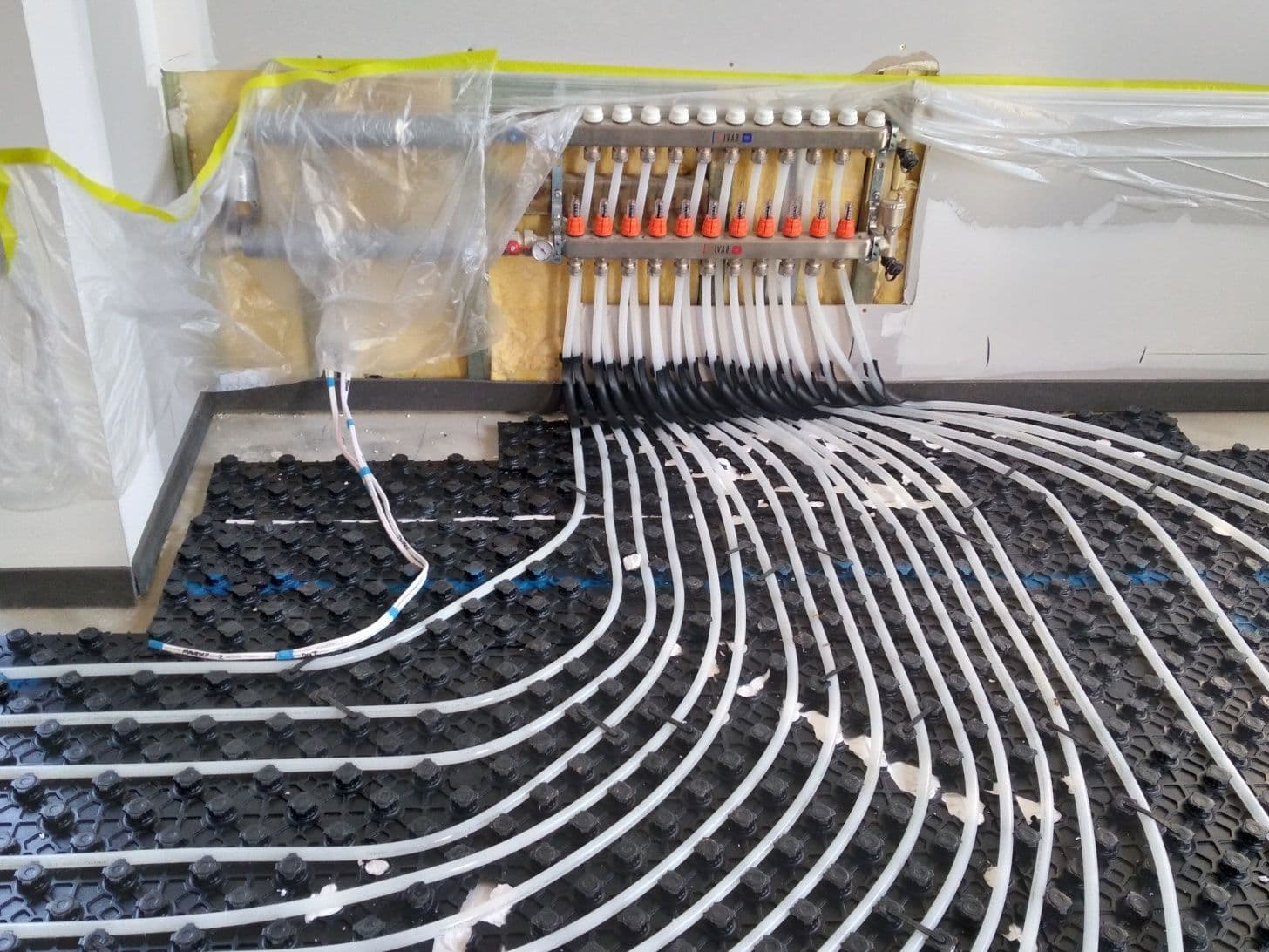 Multi-zone hydronic pipework connected to a residential heating manifold.