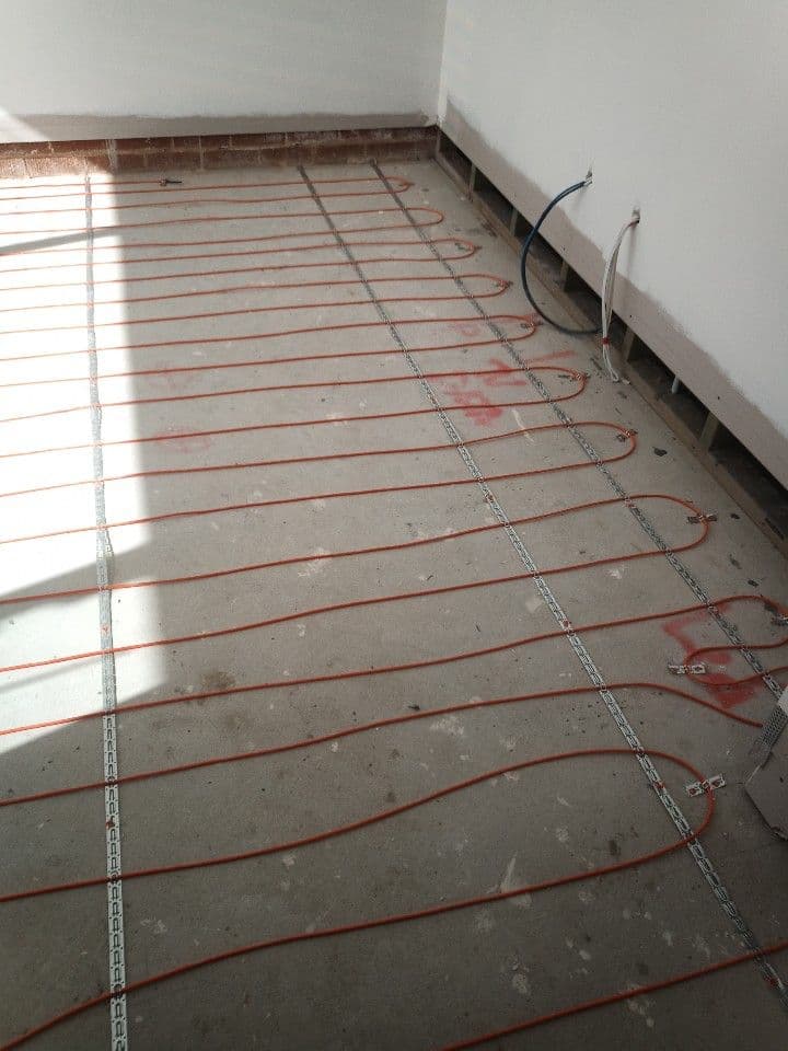 Electric underfloor heating cables installed in a sunlit room during a Lilyfield renovation.