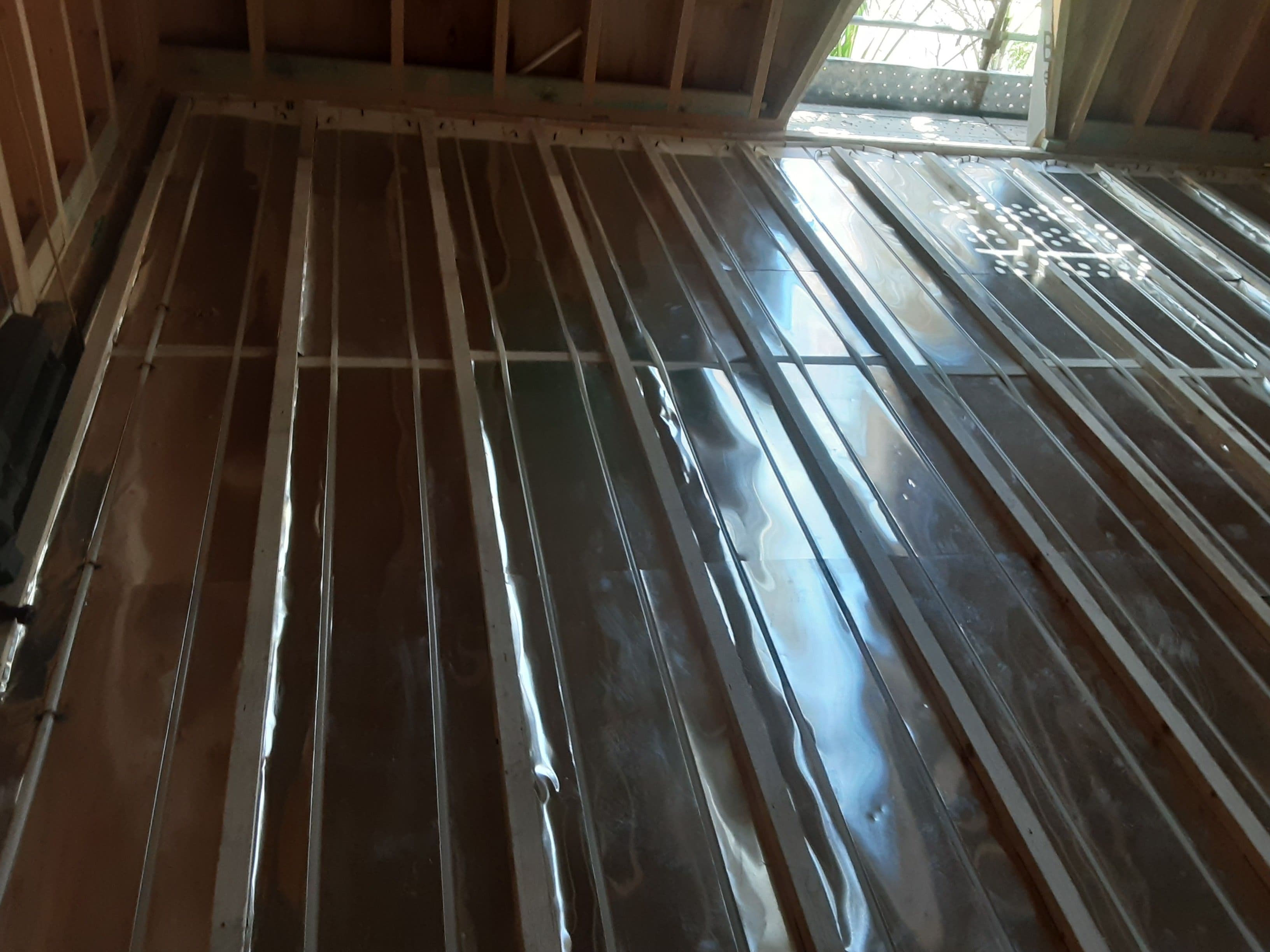 Dry hydronic floor heating installation extending across multiple residential zones.
