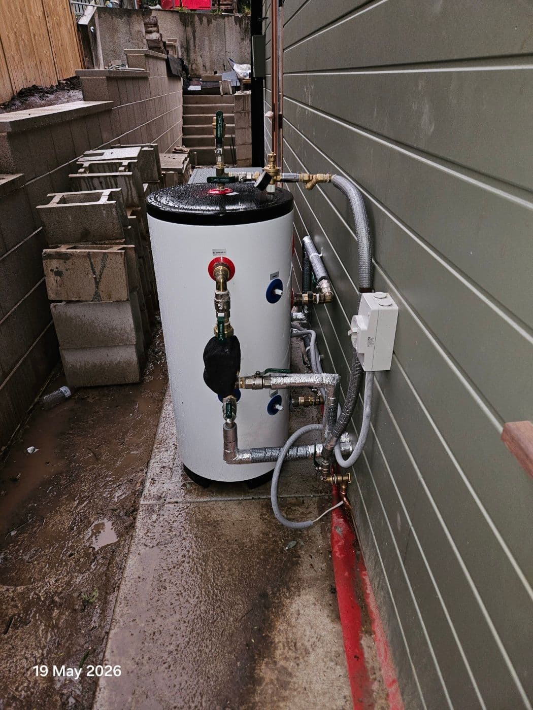 Compact R290 heat pump installed on an external concrete base in Gladesville.