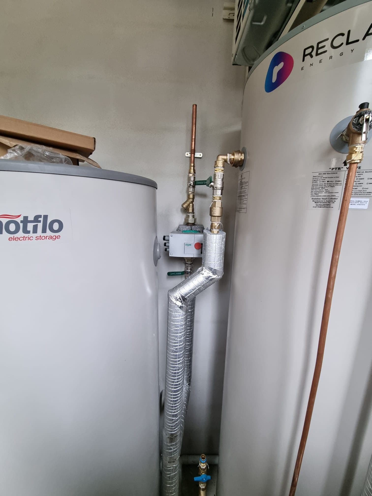 Hot water tank connections and circulation pipework installed for a residential ring main system.